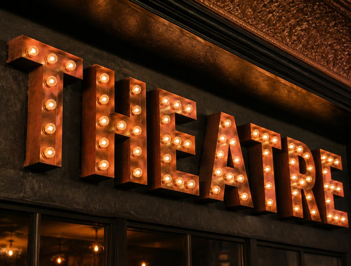 Vintage marquee letters with exposed warm bulbs on a dark wall